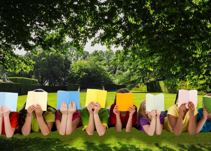 Bambini sul prato leggono libri