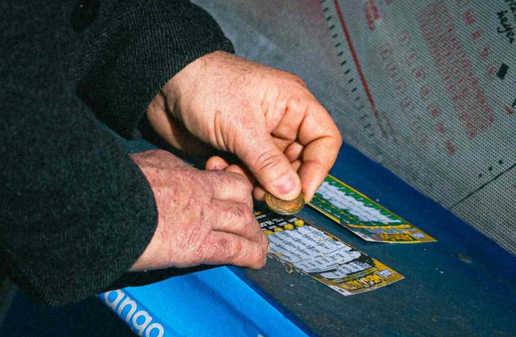 mani che grattano biglietti lotteria istantanea