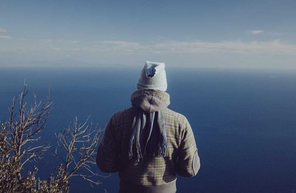 persona di spalle che guarda il mare