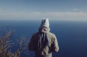 persona di spalle che guarda il mare